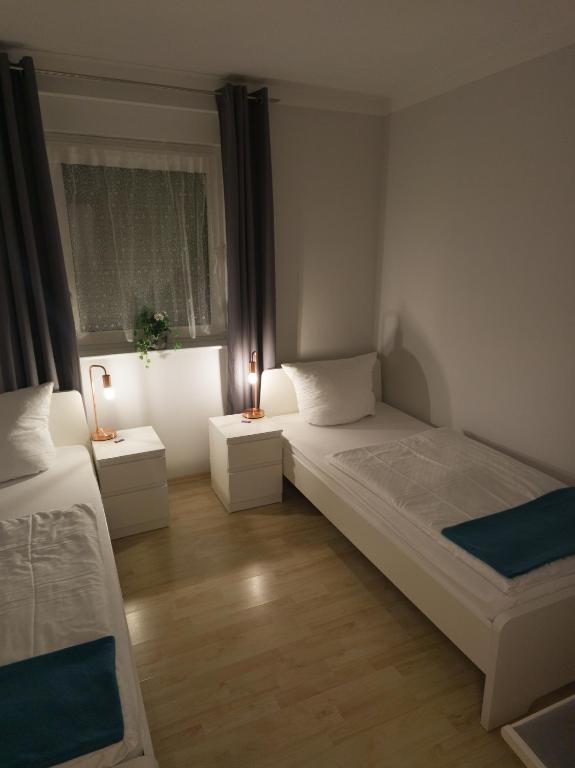 a small bedroom with two beds and two lamps at Ferienwohnung Nauen in Nauen