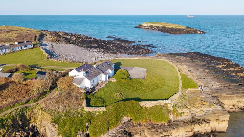 an aerial view of a house on a cliff near the ocean at Pen Bonc in Moelfre