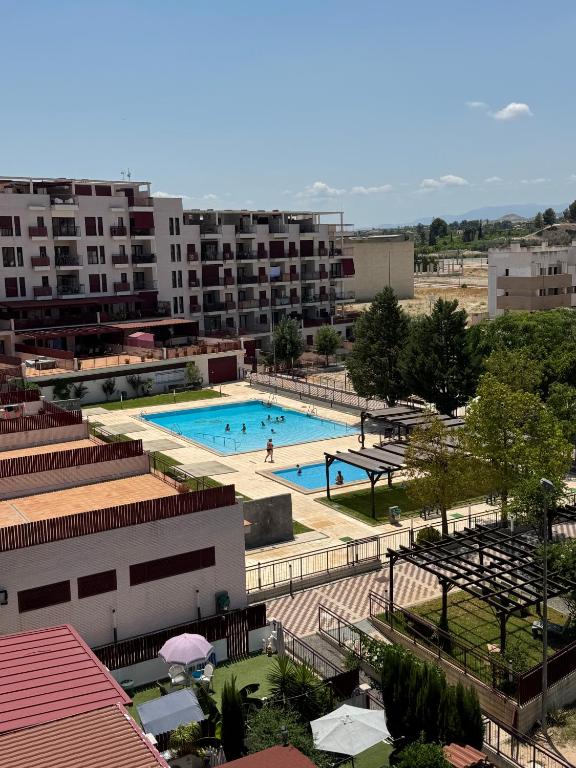 a large swimming pool in a city with buildings at Ático con terraza, piscina y jacuzzi in Villanueva de Río Segura