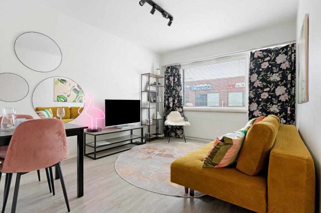 a living room with a couch and a desk and a tv at Funky City Apartment By Lapland Host in Rovaniemi