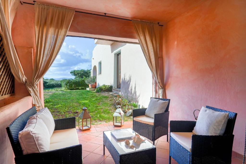 a patio with chairs and a table and a window at Cala Del Faro House in Arzachena