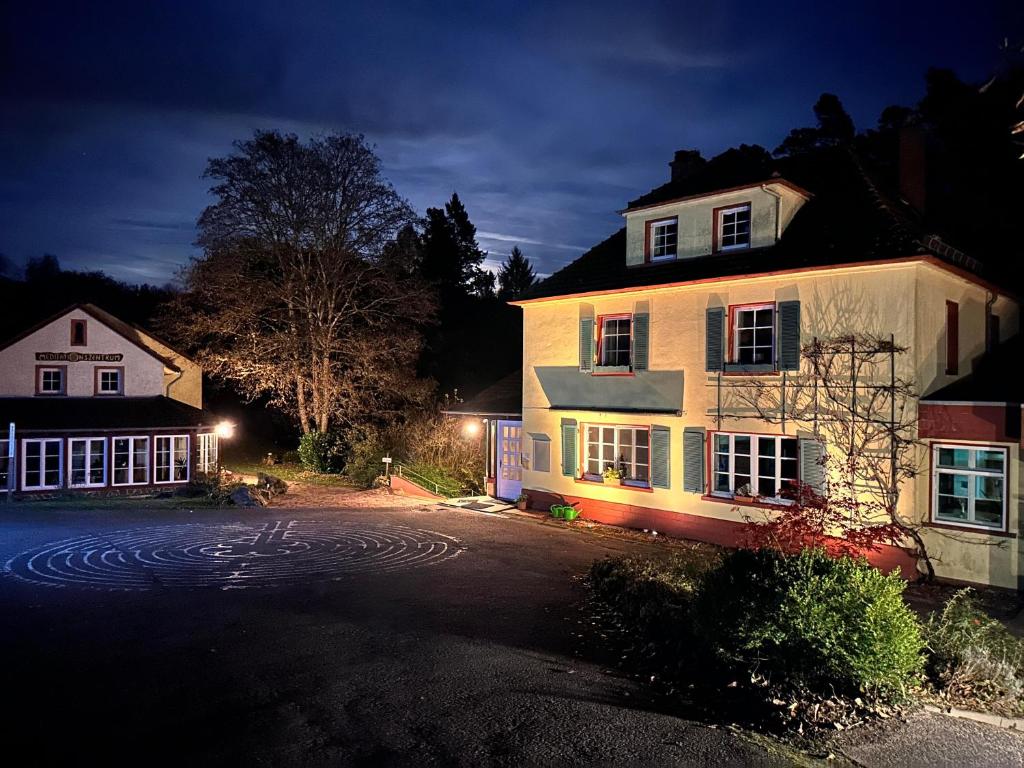 a large white house with lights in front of it at Neumühle Saar in Mettlach