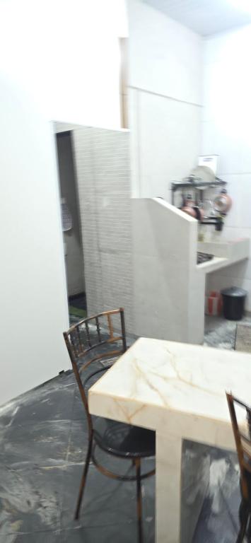 a table and chairs in a room with a kitchen at Kitnet próximo ao shopping in Campo Grande