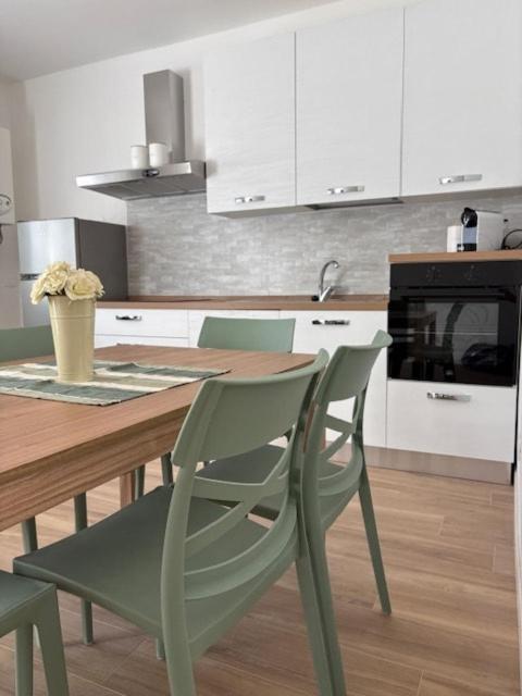 a kitchen with a wooden table with chairs and a tableasteryasteryasteryasteryastery at LA CASETTA - Clusone in Clusone