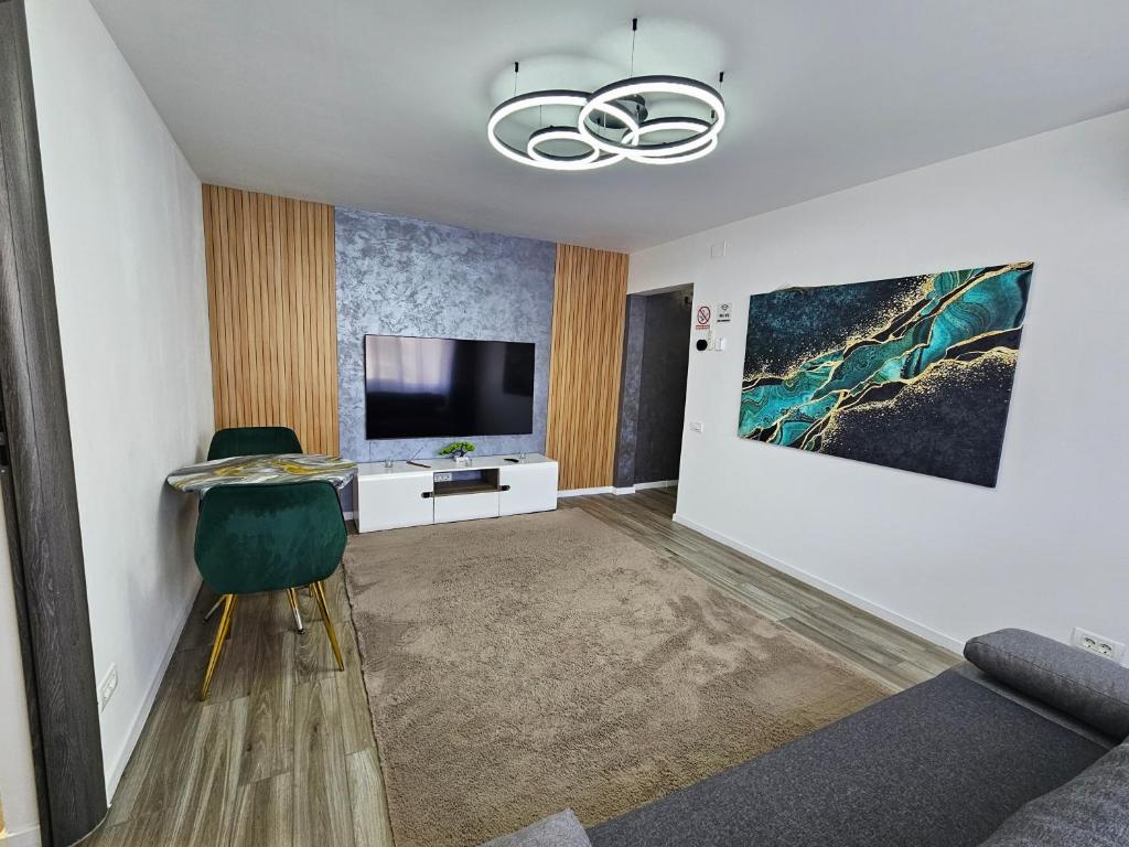 a living room with a television and a green chair at Casa Darius 1 in Alexandria