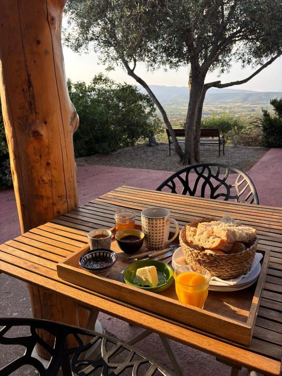 a wooden table with a tray of food on it at Chambres d'hôtes avec vue panoramique - Gîte Saint Roch in Tuchan
