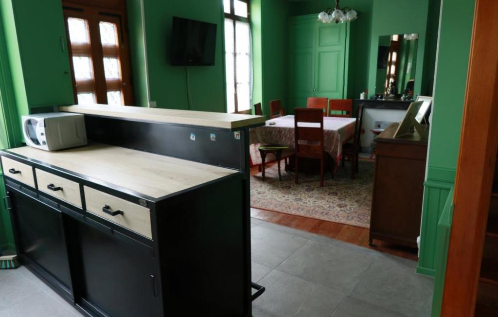 a kitchen with green walls and a dining room at Gîte Chez Claudette in Briord