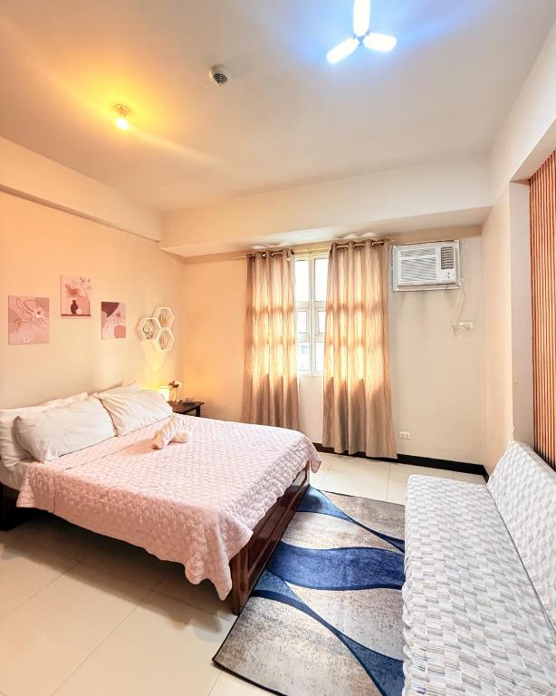 a bedroom with a bed and a window at Henry's Newport Condotel in Manila