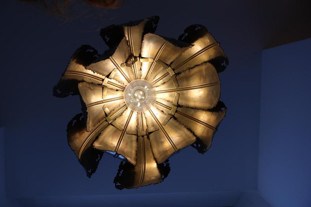 a gold ceiling light hanging from a ceiling at Lighthouse cottage in Watchet