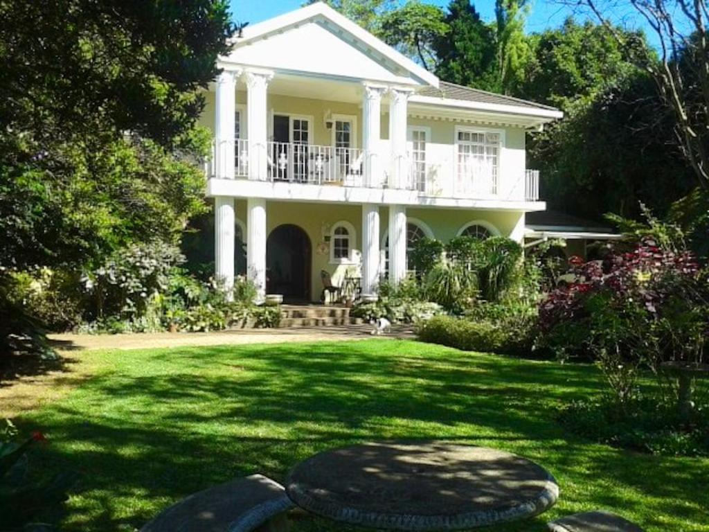 a large white house with a balcony on a lawn at Bancroft B&B in Hilton