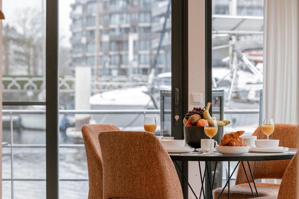 a table with a bowl of fruit and wine glasses at Houseboat-Oostende in Ostend