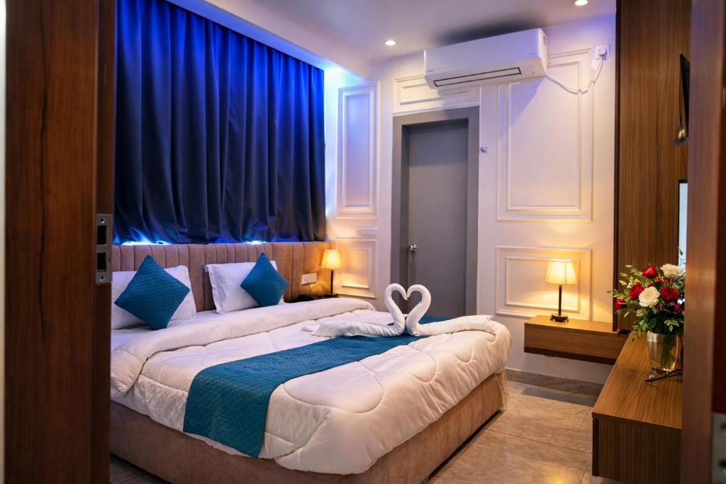 a bedroom with two beds with blue curtains at Hotel Mariott Inn in Prayagraj