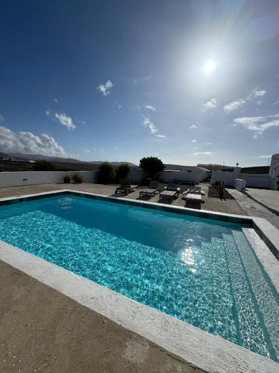 a swimming pool with blue water in a yard at El aceitunal private pool in Puerto del Rosario