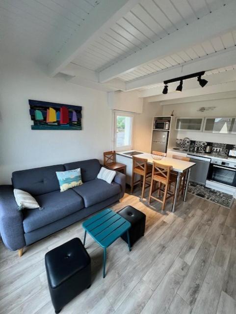 a living room with a blue couch and a table at Ty Bihan plage 4p in Carnac