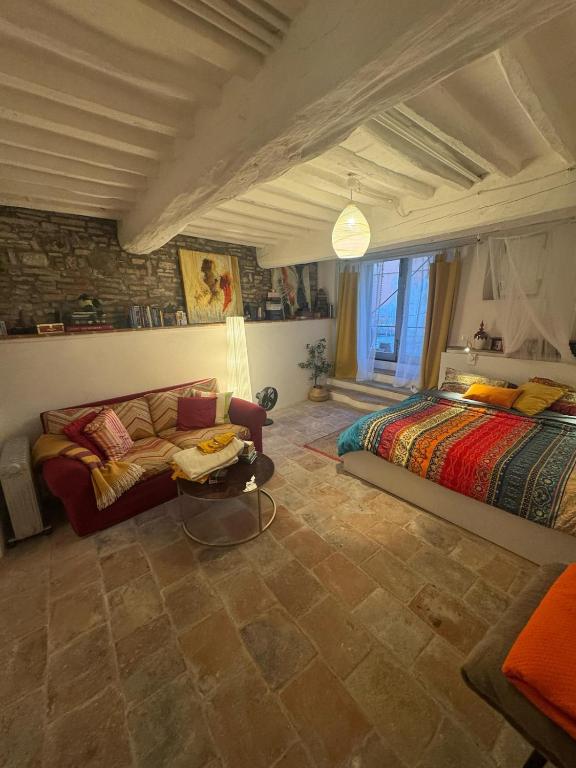 a bedroom with a bed and a couch in a room at Authentic Tuscan Studio in Lucca with Private Patio in Lucca