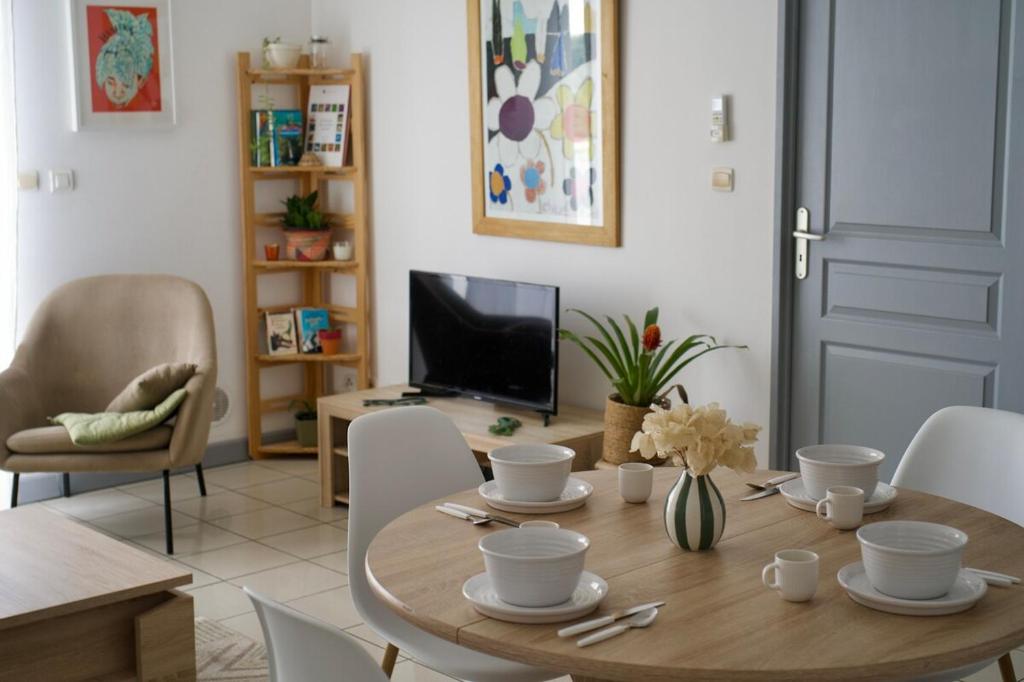 a dining room with a wooden table and chairs at Le Frangipanier in La Possession