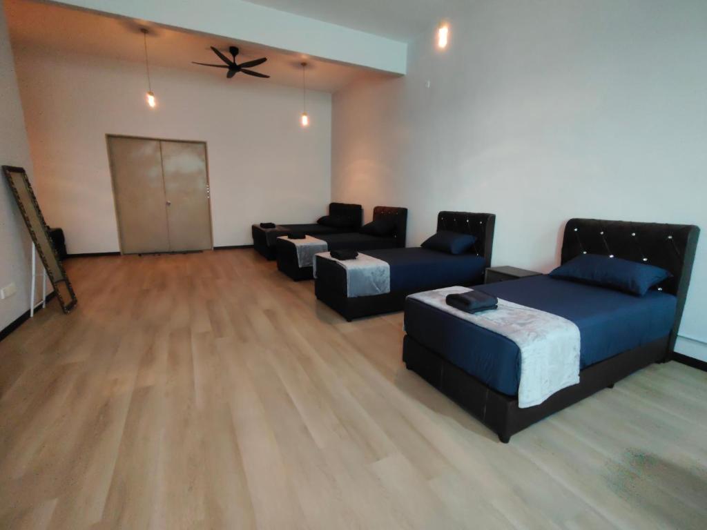 a living room with two beds and a couch at Kayangan Suite - Home Studio in Kangar