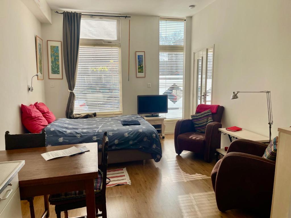a bedroom with a bed and a living room at Appartement centrum Groningen in Groningen