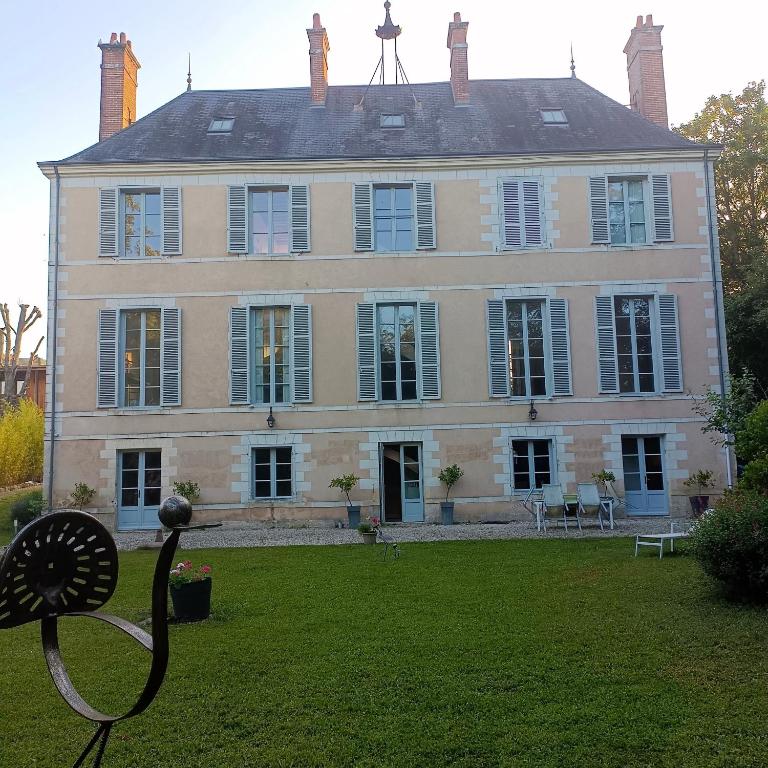 a large house with a statue in front of it at Château de la Mothe in Olivet