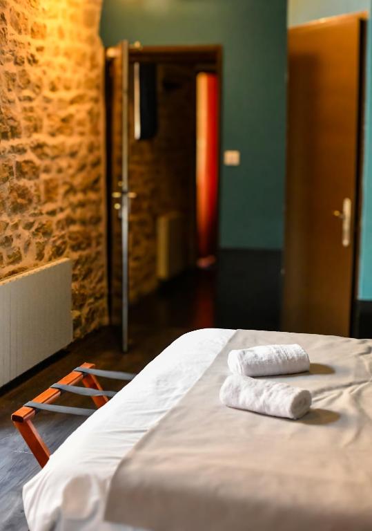 two towels sitting on a bed in a room at Le lieu in Saint-Amour