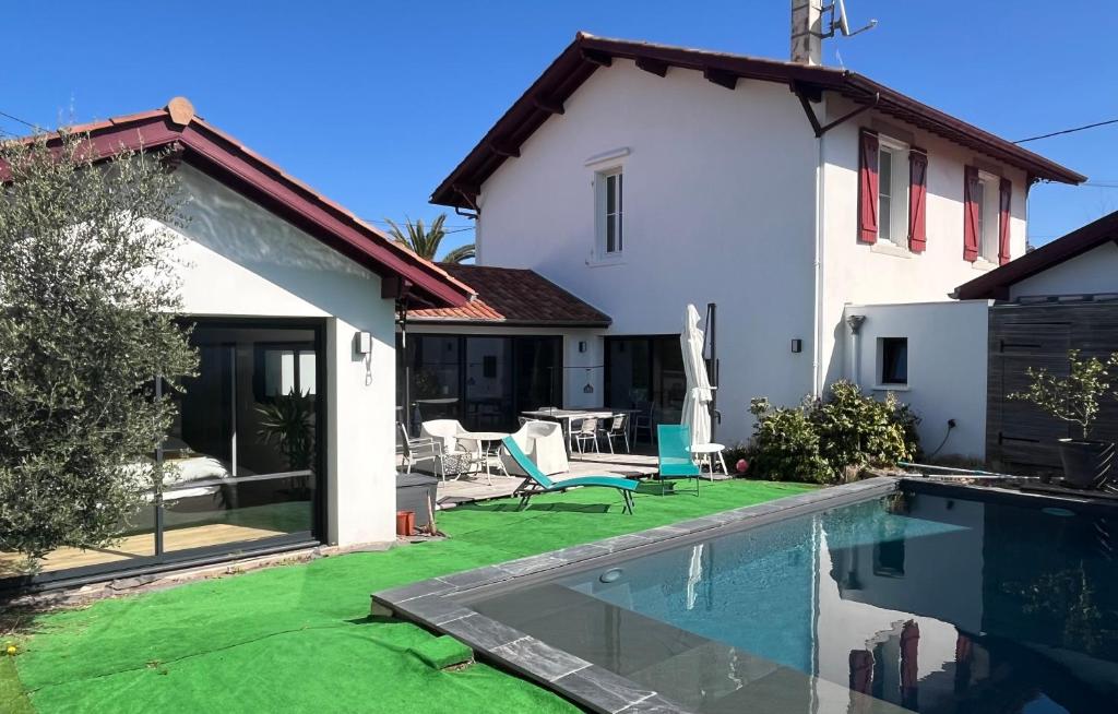 a villa with a swimming pool and a house at Villa des Loriots - Heated pool & walk to beaches - Anglet near Biarritz - Family friendly in Anglet