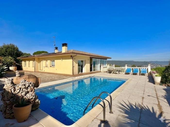 a swimming pool in front of a house at Villa Aura en Platja d'Aro in Platja d'Aro