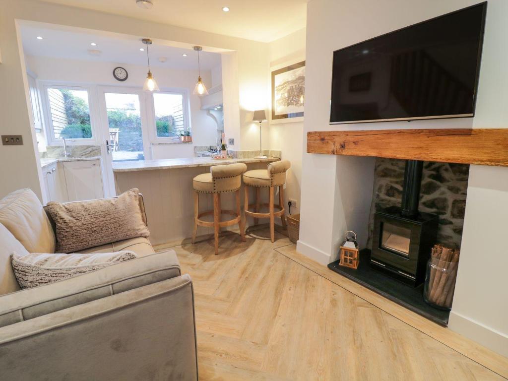 a living room with a fireplace and a tv on a wall at 8 Crown Lane in Conwy