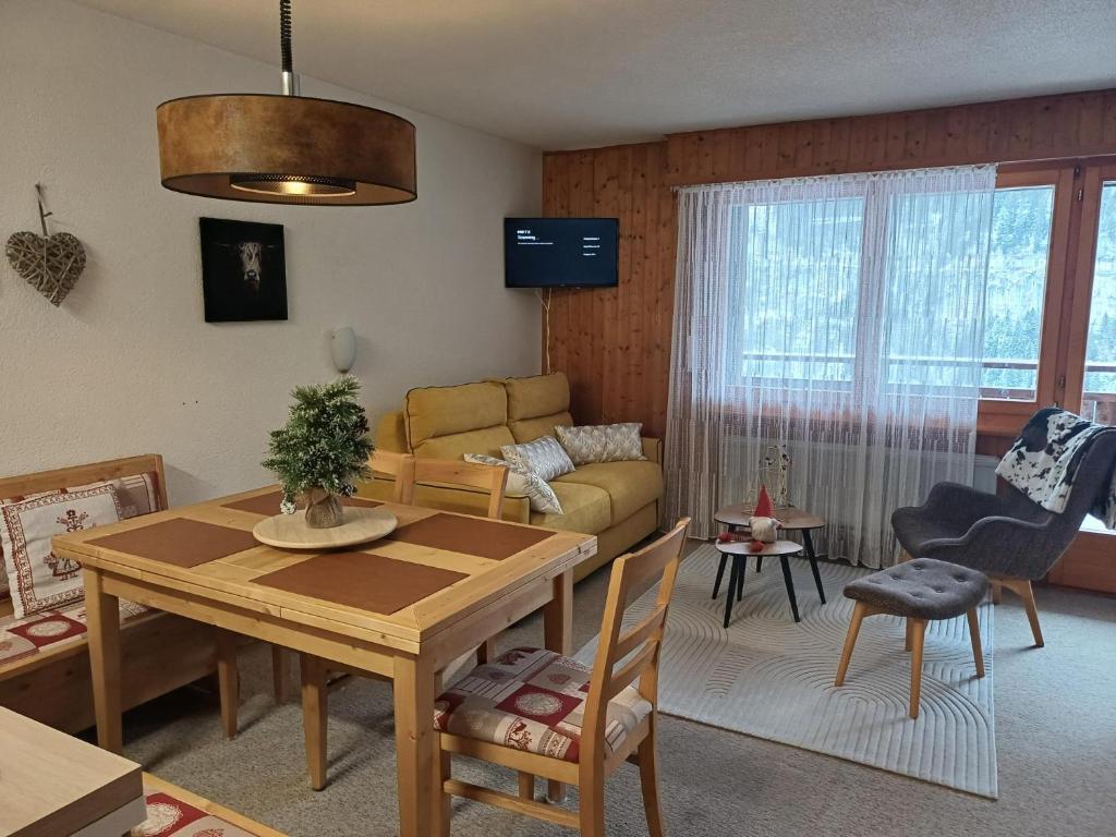 a living room with a table and a couch at Studio Le Cocon in Champéry
