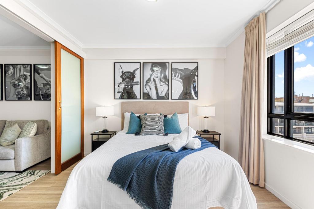 a white bedroom with a large bed and a window at Walk & Wander - A Sepal Stay in Perth