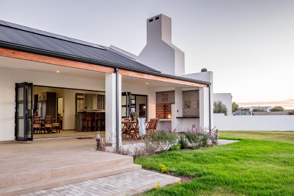 a modern house with a porch and a patio at Sea Spray Self Catering in Duyker Eiland in Britannia Bay