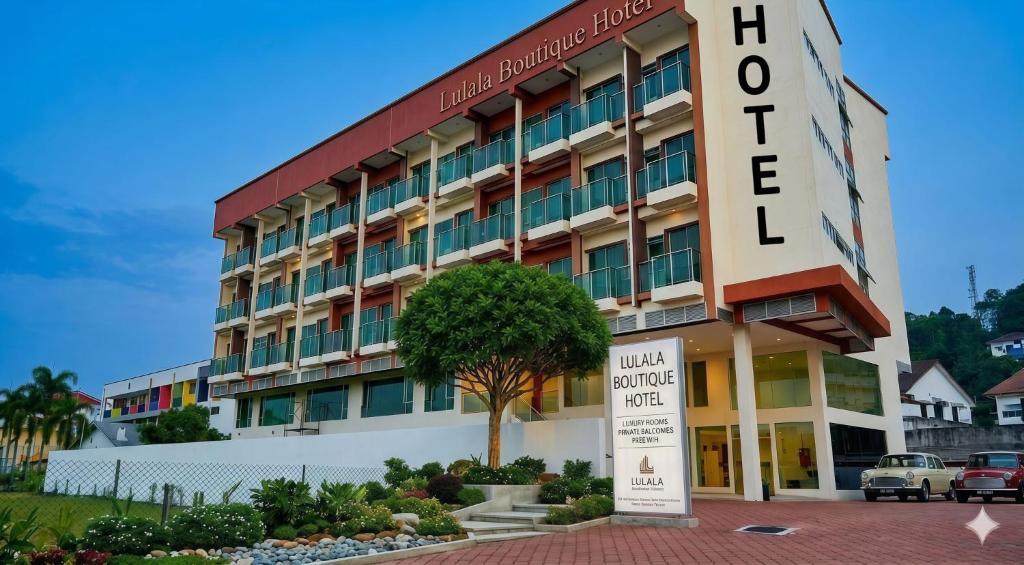 a hotel building with a sign in front of it at Lulala Boutique Hotel in Gerik