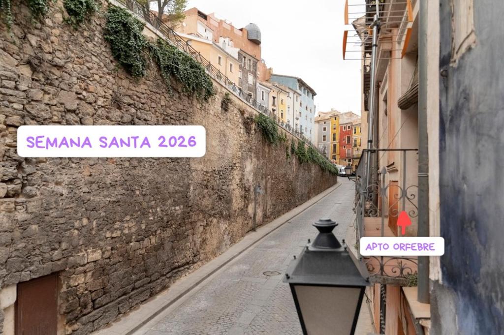 a street with a sign on the side of a building at La Casa del Orfebre in Cuenca