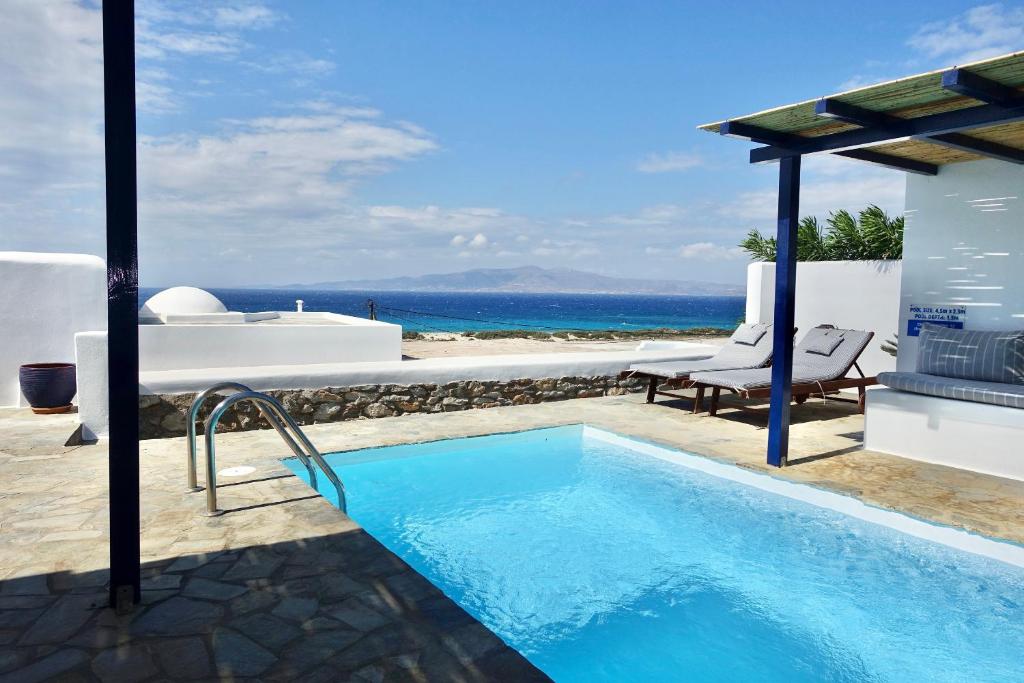 a swimming pool with a view of the ocean at Villa D - Kamari Village in Aliko Beach