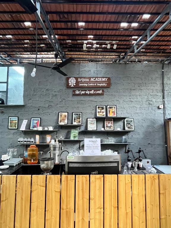 a restaurant with a counter in a room with a wall at Artjuna CoLiving in Assagao