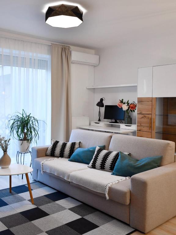 a living room with a couch with pillows on it at Kis kertes lakás in Pusztavacs