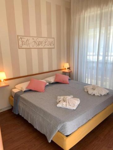 a bedroom with a bed with two towels on it at MH Hotel Maracaibo in Rimini