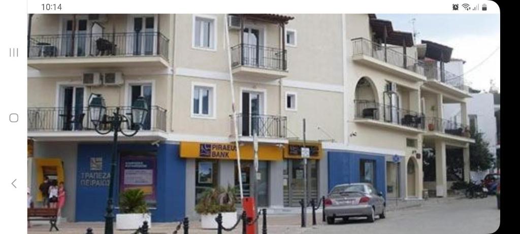 a building with a car parked in front of it at Karafelas rooms in Skiathos