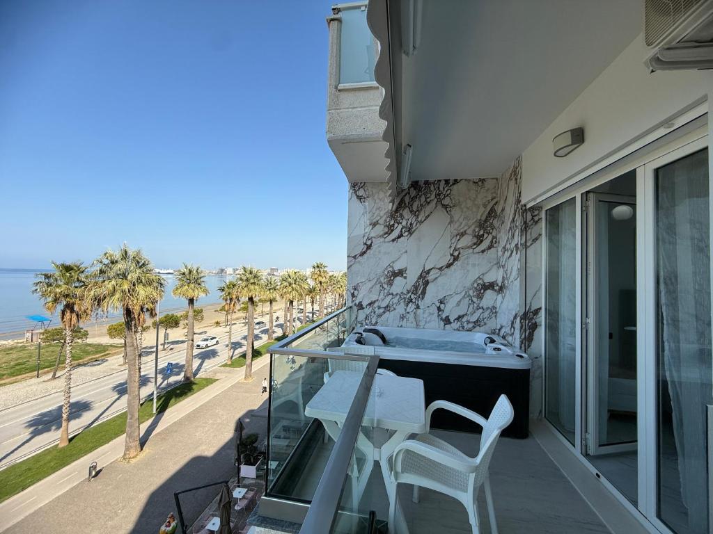 a balcony with a table and chairs and a view of the beach at Jimi Apartments in Vlorë