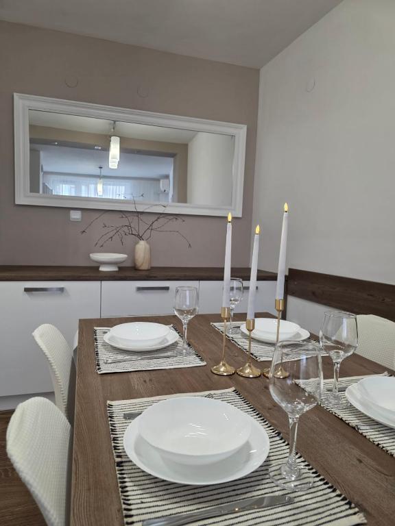 a dining room table with white plates and candles at APart Residence Shumen 1 in Shumen