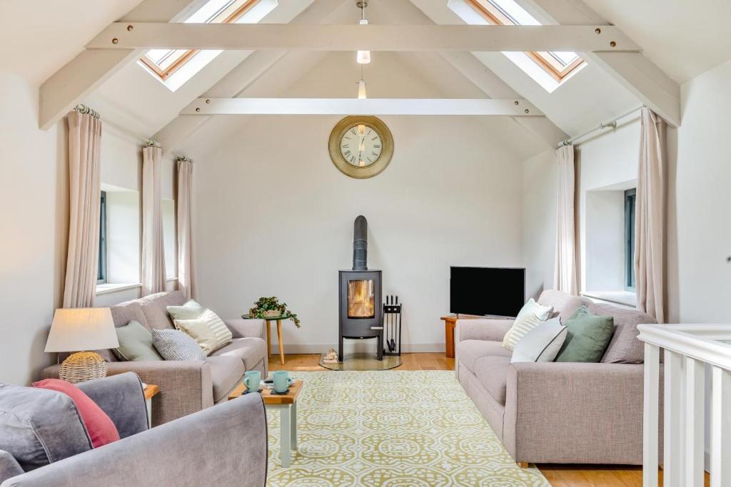 a living room with two couches and a clock on the wall at 3 Bed in Hayle oc-78551 in Hayle