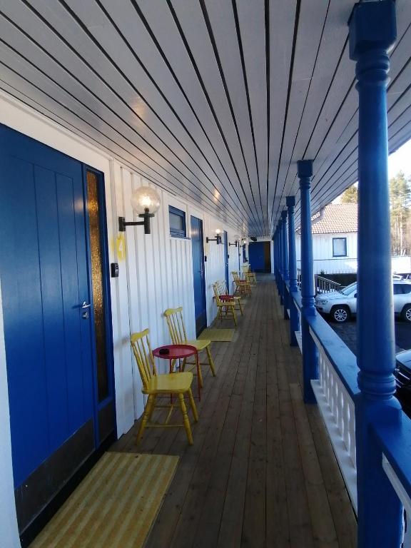 a row of chairs on a porch with blue columns at Vatnestrøm kro og Motell in Iveland