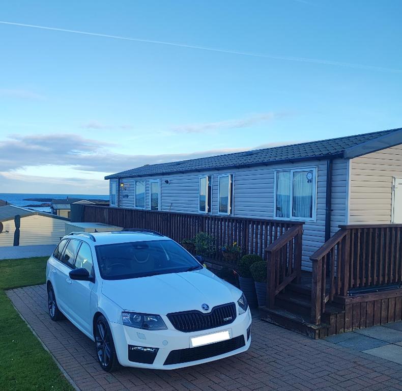 a white car parked in front of a house at Our Retreat By The Waves in Bangor
