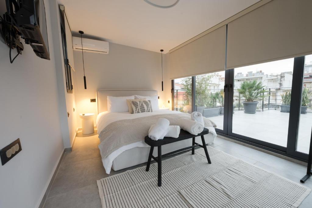 a bedroom with a white bed and a large window at Loft 77 Patras in Patra
