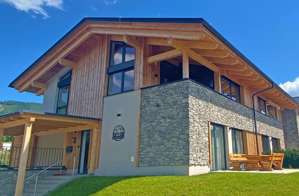 a house with a wooden roof and a bench at Almchalet Alpenglück in Sankt Lambrecht