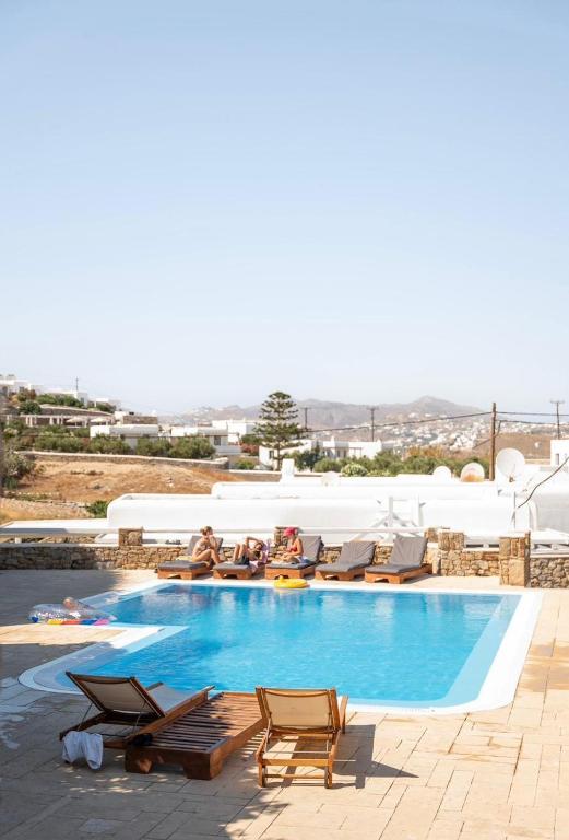 a swimming pool with chaise lounge chairs and a pool at Villa Magenta in Mikonos