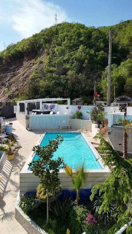 a large swimming pool with a hill in the background at Riviera 990 - Resort & Restaurant in Eşelniţa