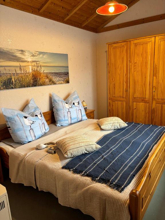 a bedroom with a large bed with blue pillows at Haus Feldblick auf Rügen in Garz