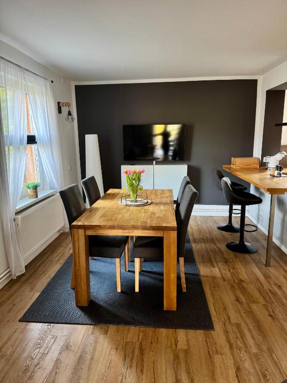 a dining room with a wooden table and chairs at stylisches Ferienhäuschen in Güstrow
