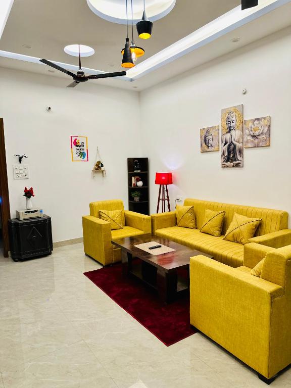 a living room with yellow couches and a coffee table at Warm Nest in Dehradun