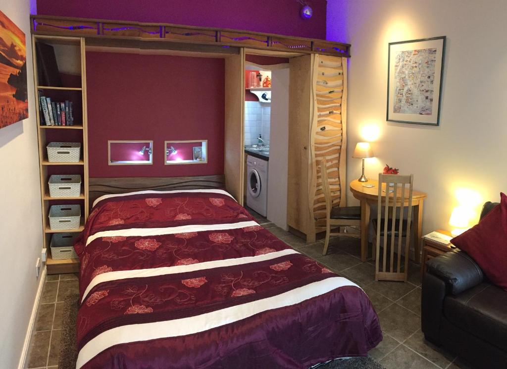 a bedroom with a bed and a table in a room at Artisan Studio in Tarbert